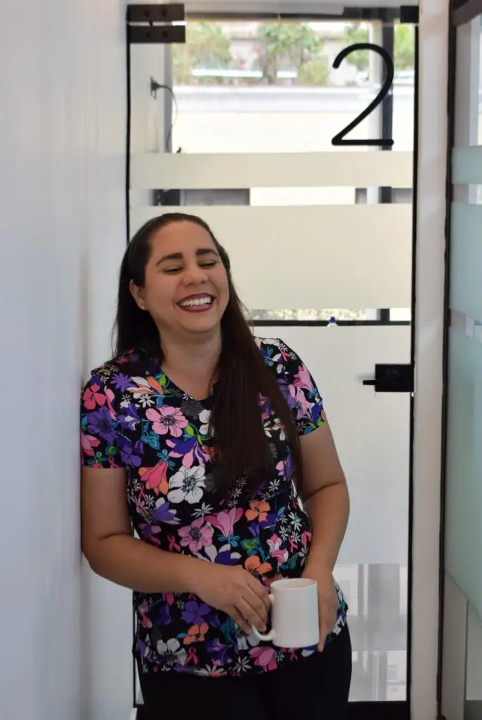 Dentista sonriendo en el pasillo de Clínica Dental Cano, transmitiendo cercanía y calidez humana.